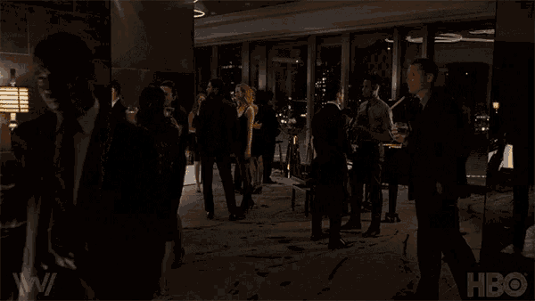 a group of people are gathered in a dark room with a hbo logo in the corner