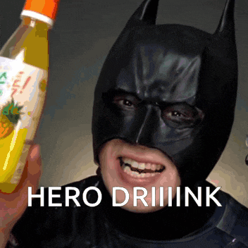 a man in a batman mask is holding a bottle of orange juice and says hero drink