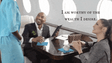 a group of people sitting around a table with the words i am worthy of the wealth i desire on the bottom