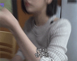 a woman in a white sweater is sitting at a table with chinese writing on her arm