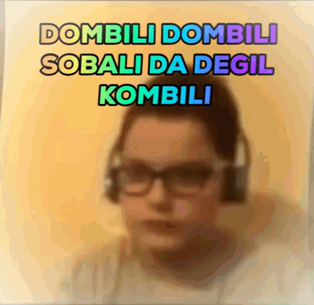 a blurred image of a person wearing headphones with the words dombili dombili sobali da degil kombili above them
