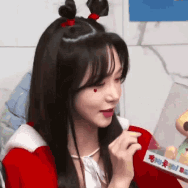 a woman is wearing a santa claus costume and holding a box .