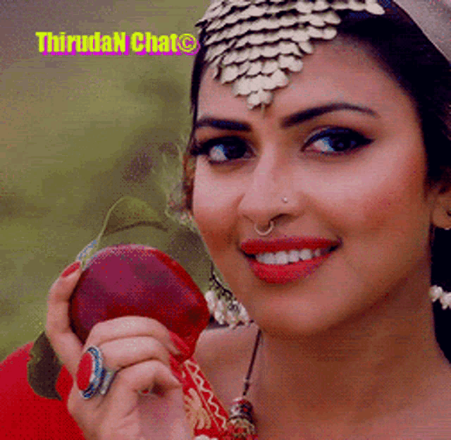 a woman with a ring on her finger is smiling and holding a red apple with the words thrudan chat below her