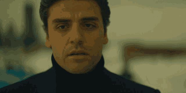 a close up of a man 's face with a turtleneck on
