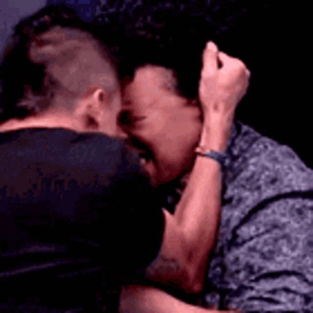 a man and a woman are hugging and kissing .