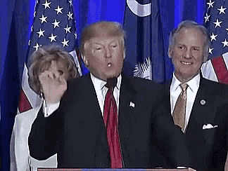donald trump is giving a thumbs up at a podium in front of american flags .