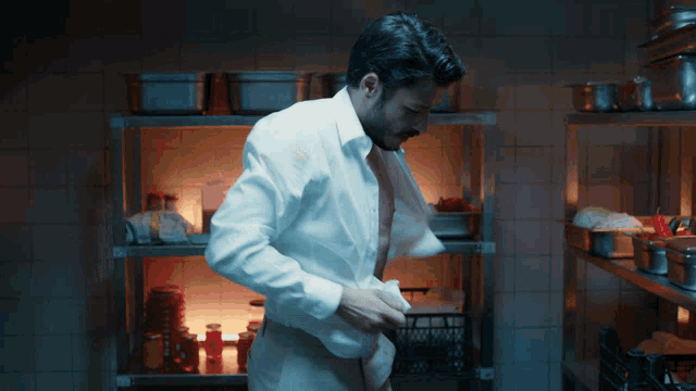 a man in a white shirt takes off his shirt