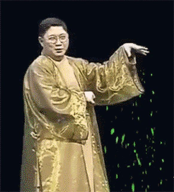 a man in a gold robe is standing in front of a green background