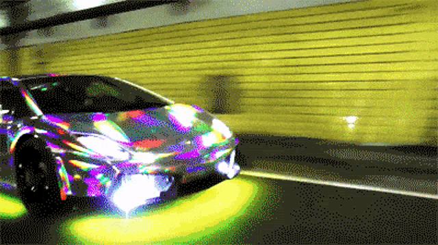a colorful car is driving through a tunnel with a yellow wall behind it
