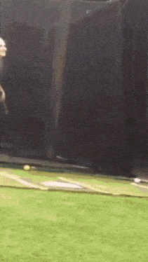 a person is throwing a baseball in a cage