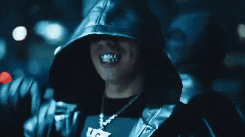 a man wearing a hooded jacket and a necklace with a uc logo on it