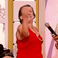 a woman in a red dress is holding a microphone