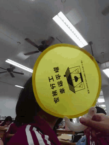 a person is holding a fan with chinese writing on it