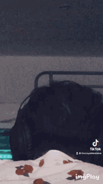 a person wearing headphones is sitting in front of a bed