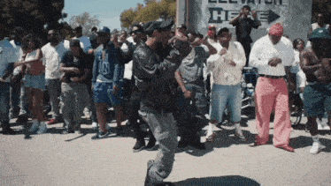 a group of people are dancing in front of a sign that says hee