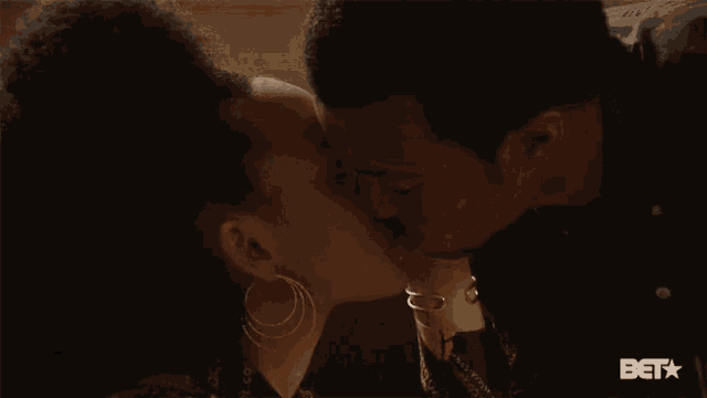 a close up of a woman 's face with a bet logo in the background