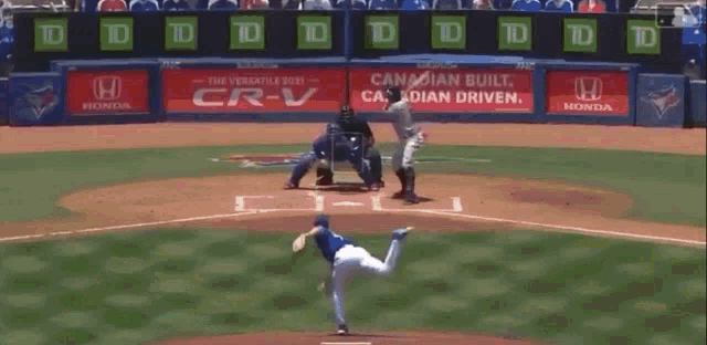 a baseball game is being played in front of a canadian built honda ad