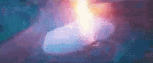 a close up of a candle burning in a dark room with a purple background .