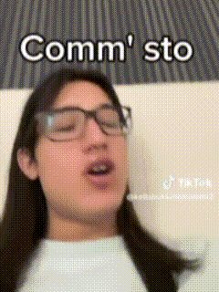 a woman wearing glasses and a white shirt says comm sto