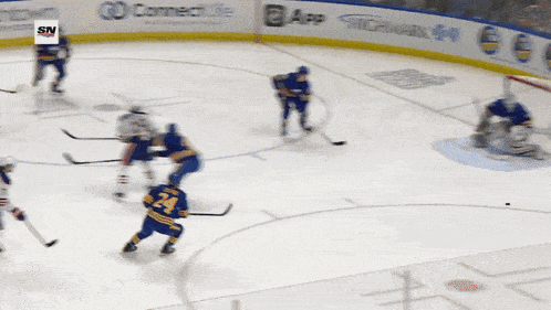 a hockey game is being played in front of a sn advertisement