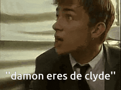a man in a suit and tie is saying " damon eres de clyde " in spanish .
