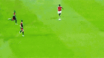 a soccer game is being played on a field with players in red and black uniforms