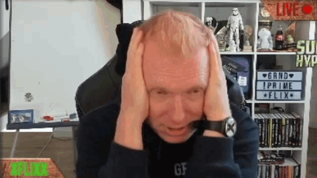 a man is covering his ears in front of a sign that says " live "