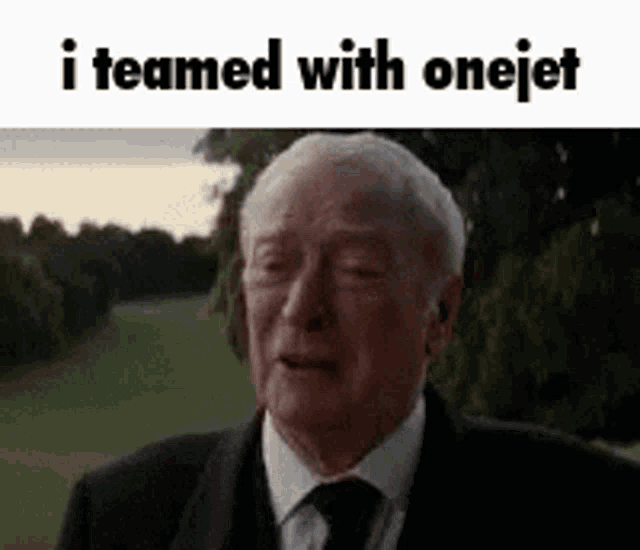 an older man in a suit and tie is standing in front of a field .