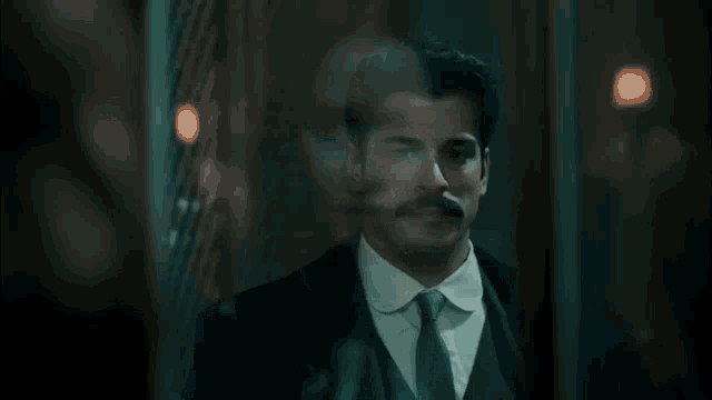a man with a mustache is smoking a cigar