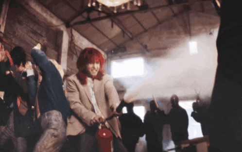 a woman with red hair is using a red fire extinguisher