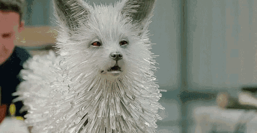 a close up of a white fox with red eyes covered in plastic sticks .