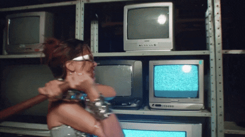 a woman is standing in front of a row of televisions including a panasonic