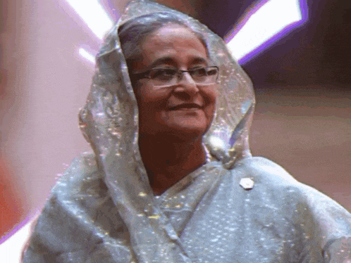 a woman wearing glasses and a veil is smiling for the camera