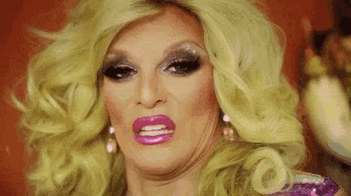 a drag queen with blonde hair and pink lipstick is making a face .