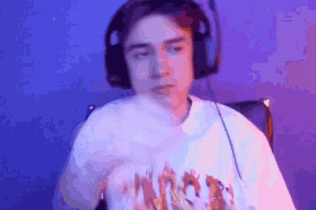 a man wearing headphones and a white shirt that says thrasher on it