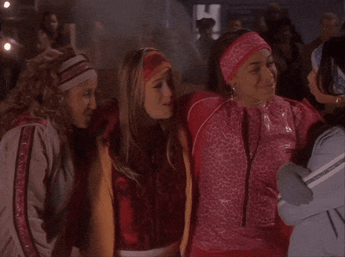 a group of girls hugging each other with one wearing a pink headband