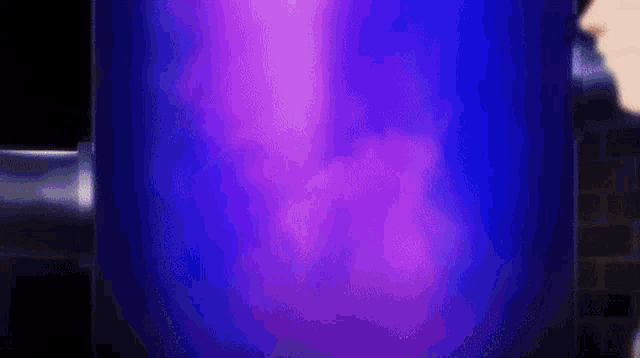 a person is standing in front of a blue and purple glowing object .