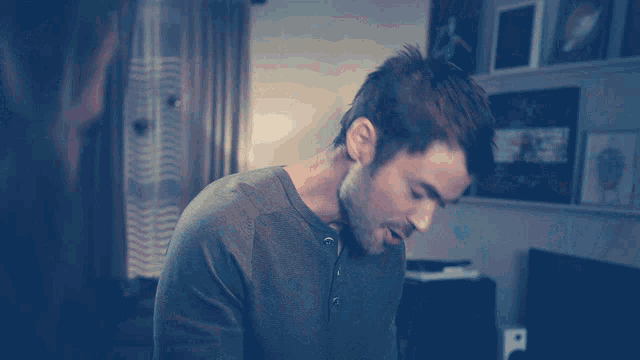 a man in a gray shirt is looking down