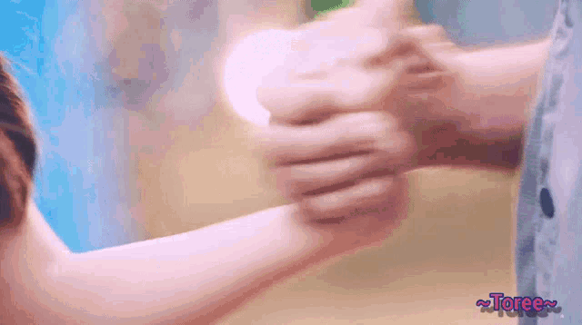 a person holding another person 's hand with the word toree on the bottom right