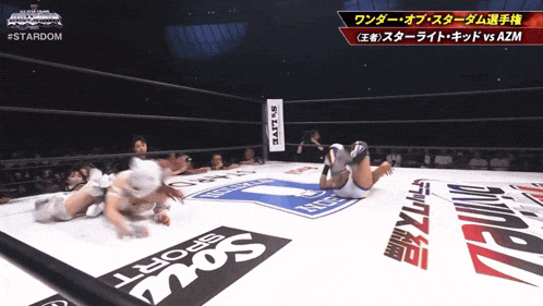 two women wrestling in a ring with a sign that says stardom