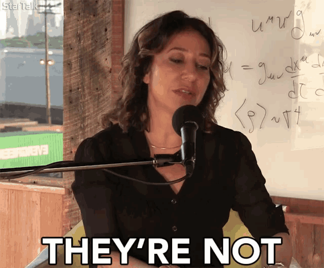 a woman speaking into a microphone with the words they 're not above her