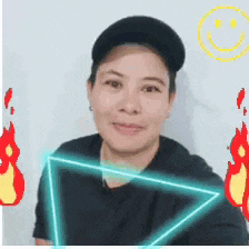 a woman wearing a hat and a black shirt is smiling with a smiley face behind her
