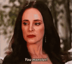 a woman with long dark hair and red lipstick is saying `` you monster '' .