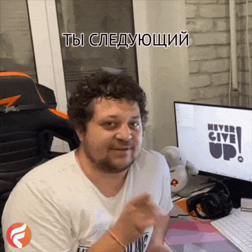 a man sitting in front of a computer with the words never give up on it
