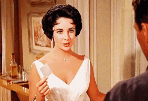 a woman in a white dress holding a piece of paper