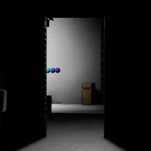 a dark room with a few balls hanging from the wall