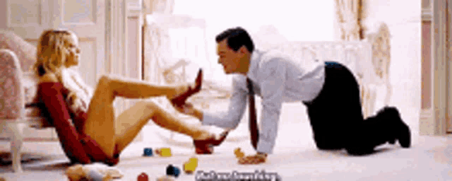 a man is kneeling down and kissing a woman 's feet