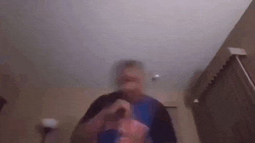 a blurry picture of a man standing in a living room holding a microphone .