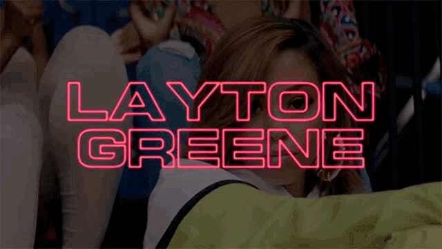 a neon sign that says layton greene is lit up