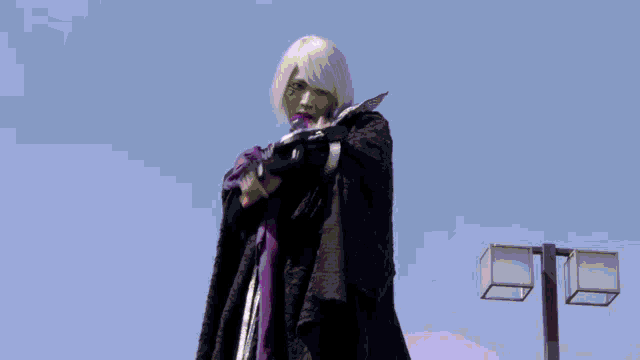 a person in a black cape is standing in front of a street light